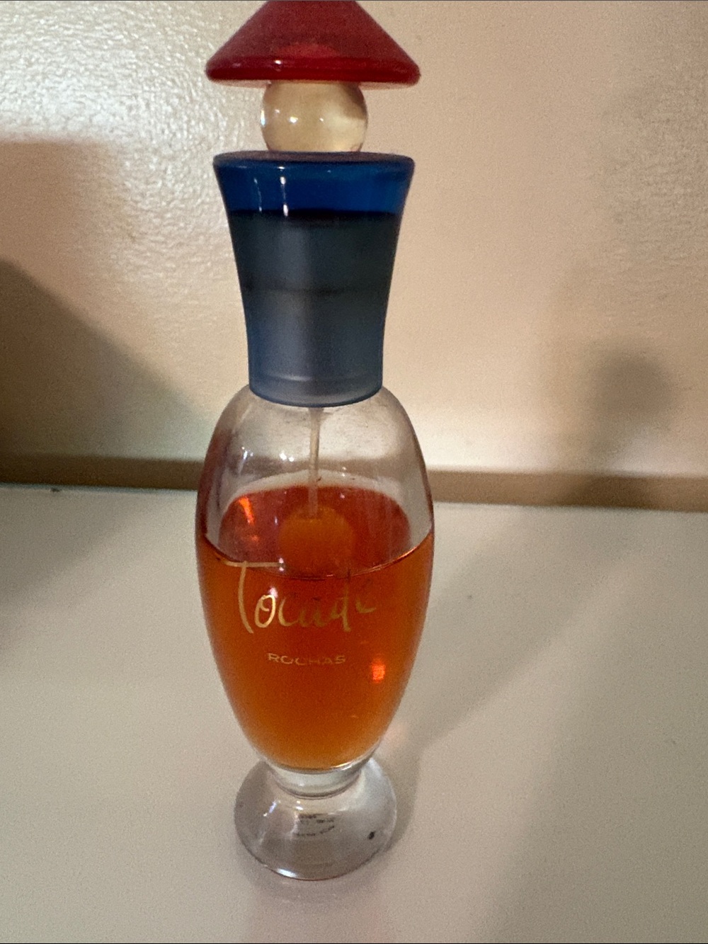 Rochas Tocade Eau de Parfum Bottle with Amber Liquid and Blue Accents